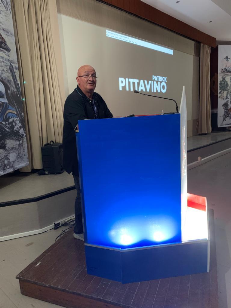 Patrick derrière un pupitre, animant une conférence